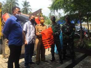 GMC team with local officials and Indonesian military personnel during a community engagement event